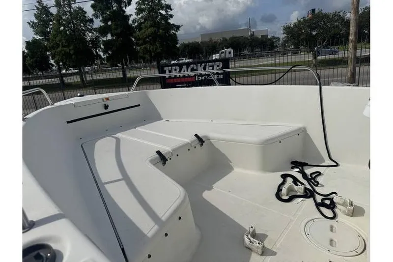 Slide: The Image of 2000 Hydra-Sports 18cc boat interior with console and seating, docked near a flag. - 11