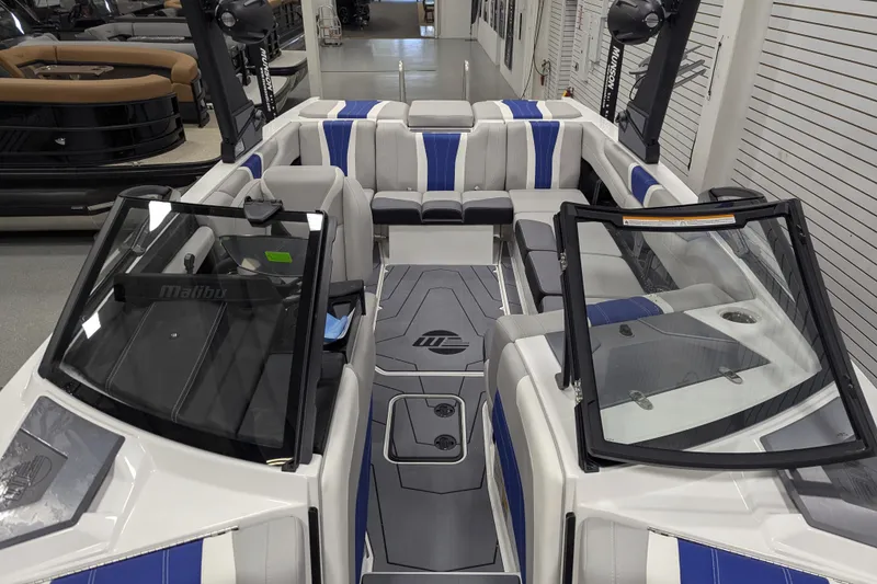 Slide: The Image of 2026 Malibu Wakesetter 22 LSV interior with blue and gray seating, showcased in a showroom. - 11