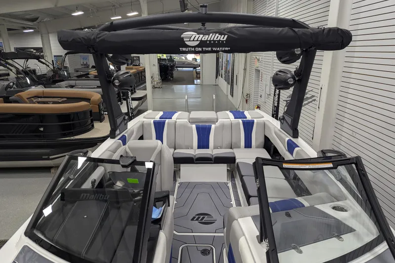 Slide: The Image of 2026 Malibu Wakesetter 22 LSV boat interior with blue and white seating in showroom. - 12