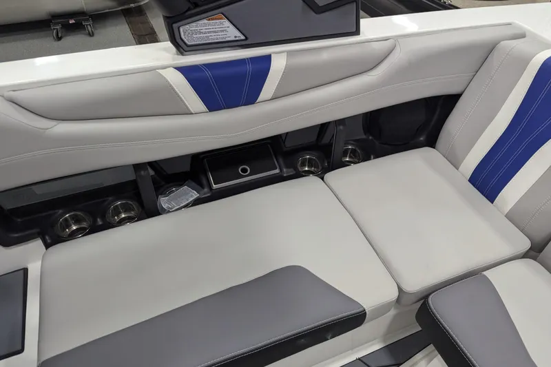 Slide: The Image of 2026 Malibu Wakesetter 22 LSV interior with gray and blue seating, cup holders, and storage. - 14