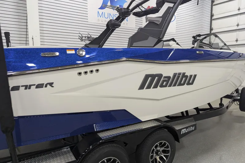 Slide: The Image of 2026 Malibu Wakesetter 22 LSV boat in showroom, blue and white design. - 3