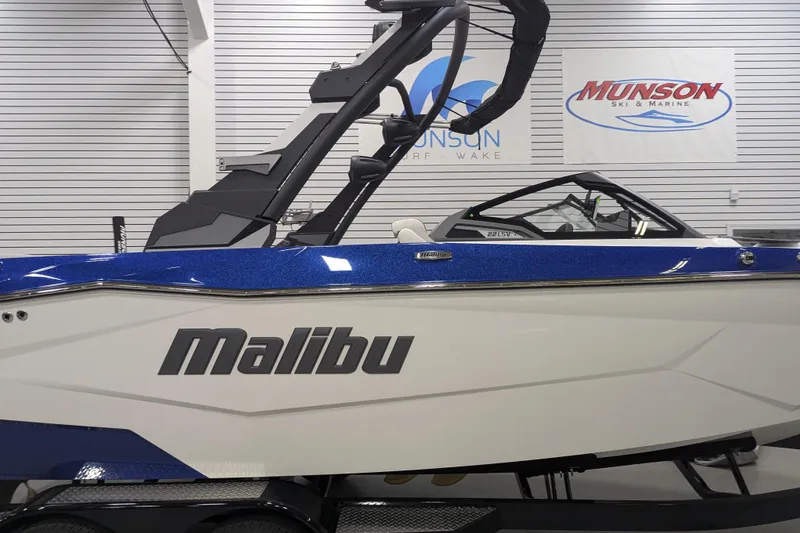Slide: The Image of 2026 Malibu Wakesetter 22 LSV boat in showroom, featuring sleek design and blue accents. - 4