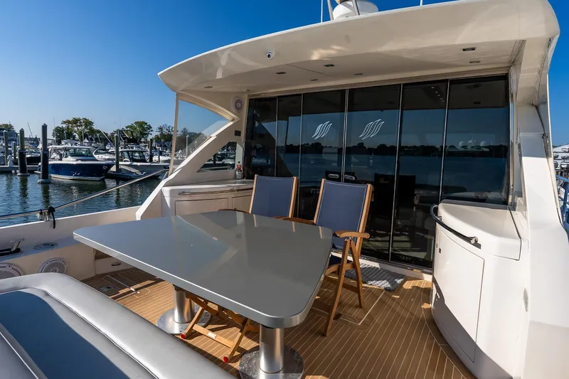 Slide: The Image of Luxury Uniesse 55S yacht deck with seating and table, docked at marina, 2011 model. - 6