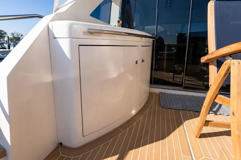 Slide: The Image of 2011 Uniesse 55S yacht deck with sleek cabinetry and wooden chair. - 10