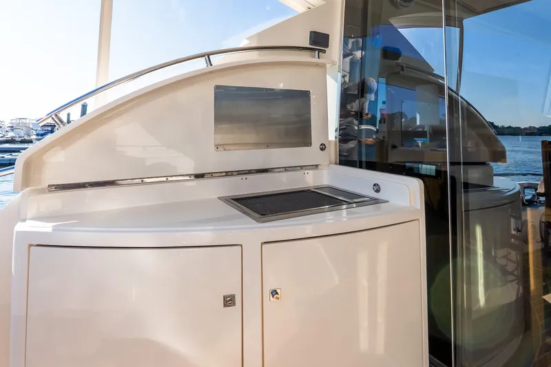Slide: The Image of Outdoor kitchen area on a 2011 Uniesse 55S yacht, featuring a grill and storage. - 11