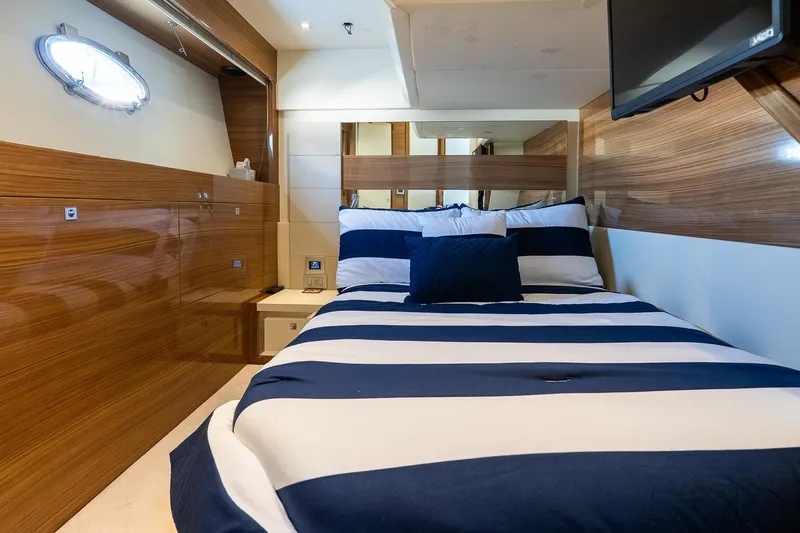 Slide: The Image of Luxurious cabin interior of 2011 Uniesse 55S yacht with striped bedding and wood paneling. - 33