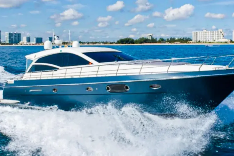 The Image of 2011 Uniesse 55S yacht cruising on blue ocean with city skyline in background. - 0