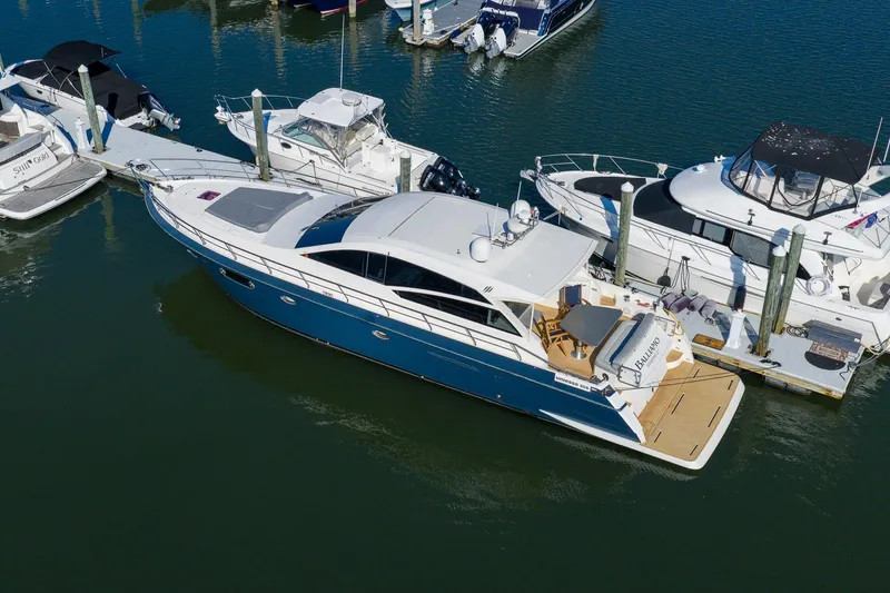 Slide: The Image of 2011 Uniesse 55S yacht docked at marina, surrounded by other boats. - 2