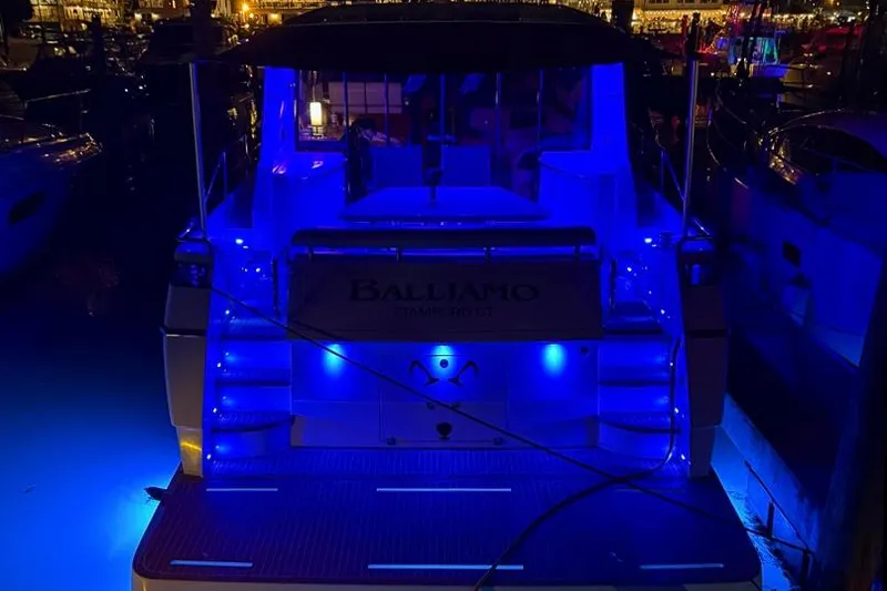 Slide: The Image of 2011 Uniesse 55S yacht illuminated with blue lights at night in a marina. - 46