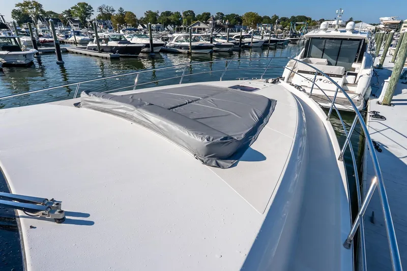 Slide: The Image of 2011 Uniesse 55S yacht docked at marina, showcasing sleek deck design. - 42
