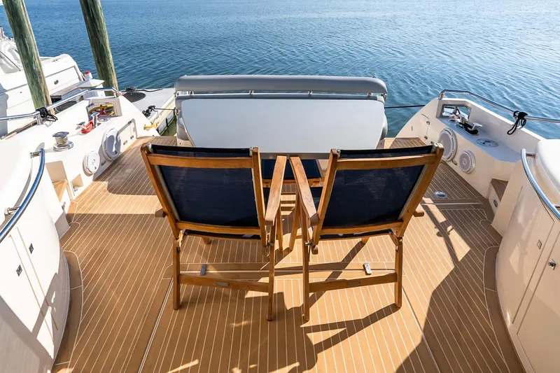 Slide: The Image of Deck of 2011 Uniesse 55S yacht with wooden chairs overlooking the water. - 9