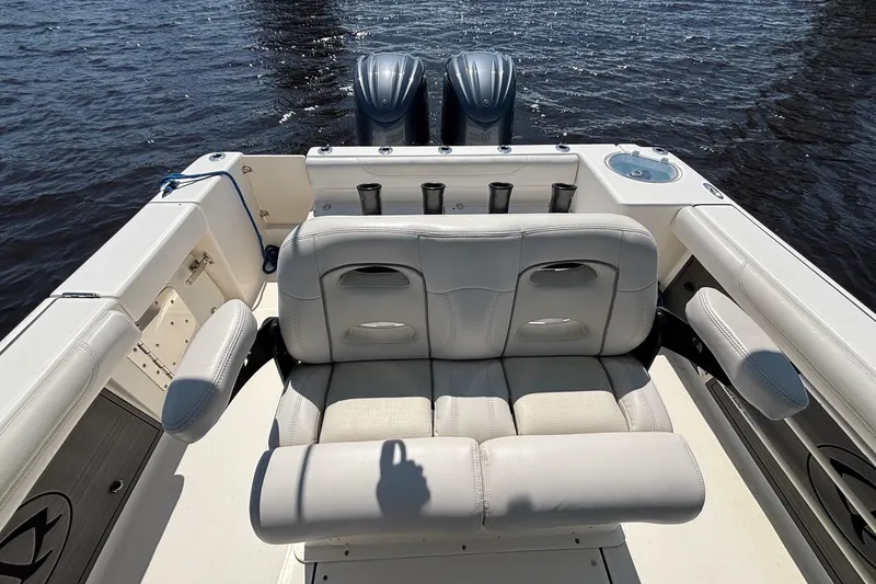 Slide: The Image of 2023 Sea Born LX26 Center Console boat interior with cushioned seating and dual engines. - 13