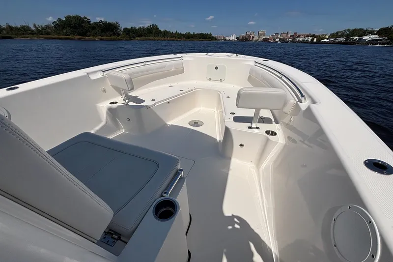 Slide: The Image of 2023 Sea Born LX26 Center Console boat interior on calm water, showcasing seating and design. - 14