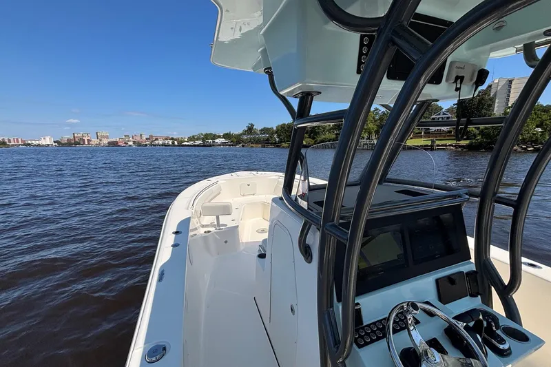 Slide: The Image of 2023 Sea Born LX26 Center Console boat on calm water with cityscape in background. - 18