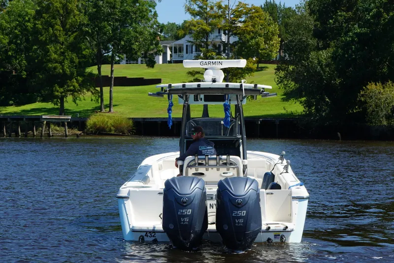 Slide: The Image of 2023 Sea Born LX26 Center Console boat on a scenic river with lush greenery. - 5