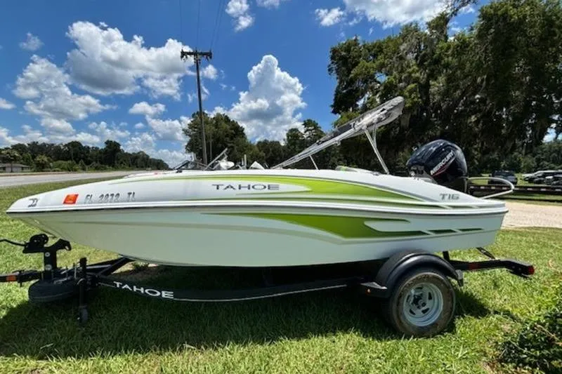 The Image of 2023 Tahoe T16 boat on trailer, parked on grass under a blue sky. - 0