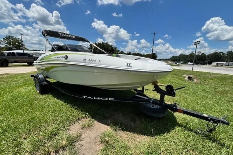 Slide: The Image of 2023 Tahoe T16 boat on trailer, parked on grass under a blue sky. - 3