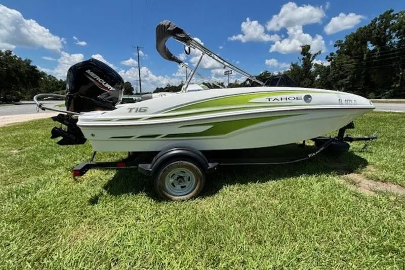 Slide: The Image of 2023 Tahoe T16 boat on trailer, green and white design, parked on grass under blue sky. - 4