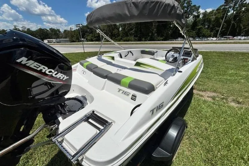 Slide: The Image of 2023 Tahoe T16 boat with Mercury engine, parked on grass under a blue sky. - 5