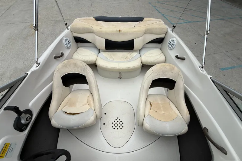 Slide: The Image of 2010 Tahoe Q4 boat interior with worn white and black seating. - 10