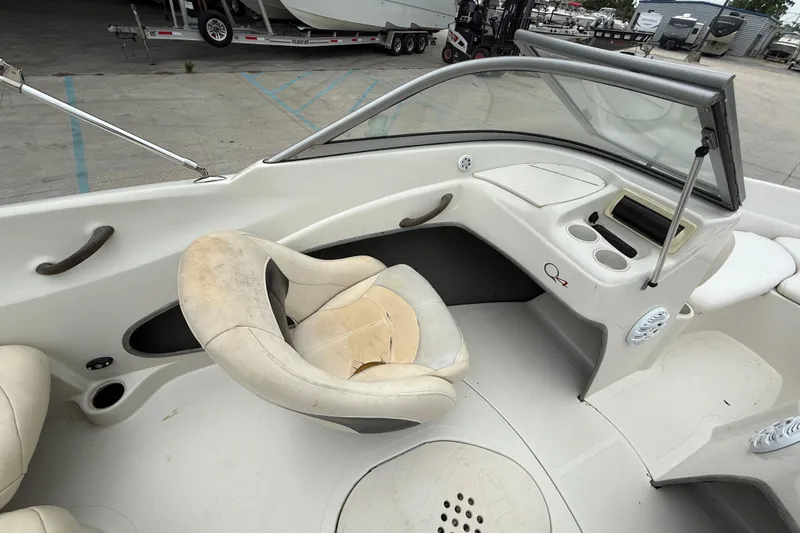Slide: The Image of 2010 Tahoe Q4 boat interior with worn seating and dashboard, parked in a marina. - 11