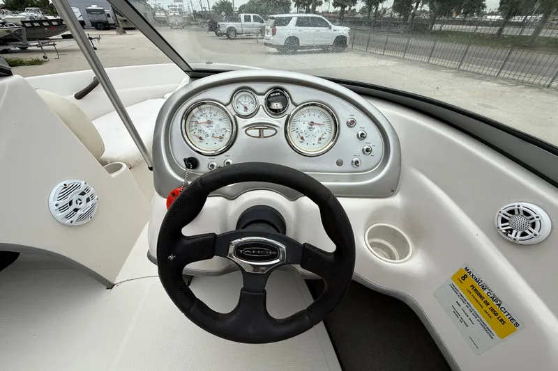 Slide: The Image of Steering wheel and dashboard of a 2010 Tahoe Q4 boat, featuring gauges and controls. - 13