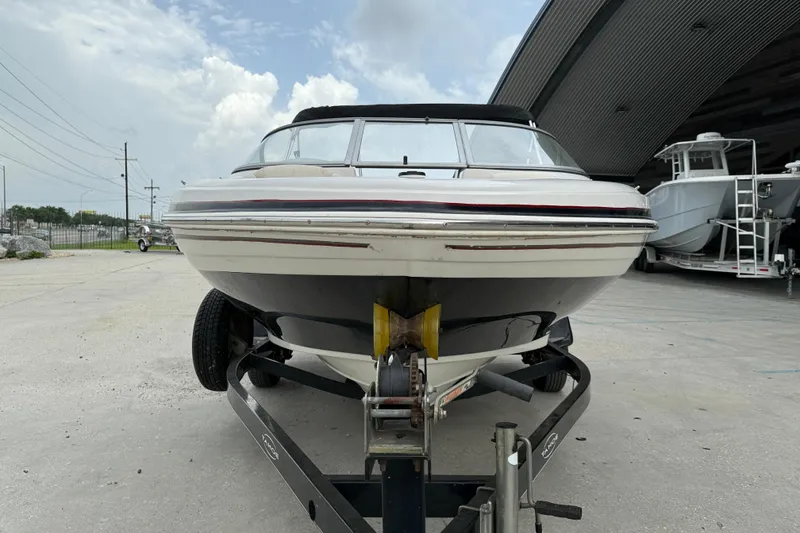 Slide: The Image of 2010 Tahoe Q4 boat on trailer, parked outdoors under cloudy sky. - 3
