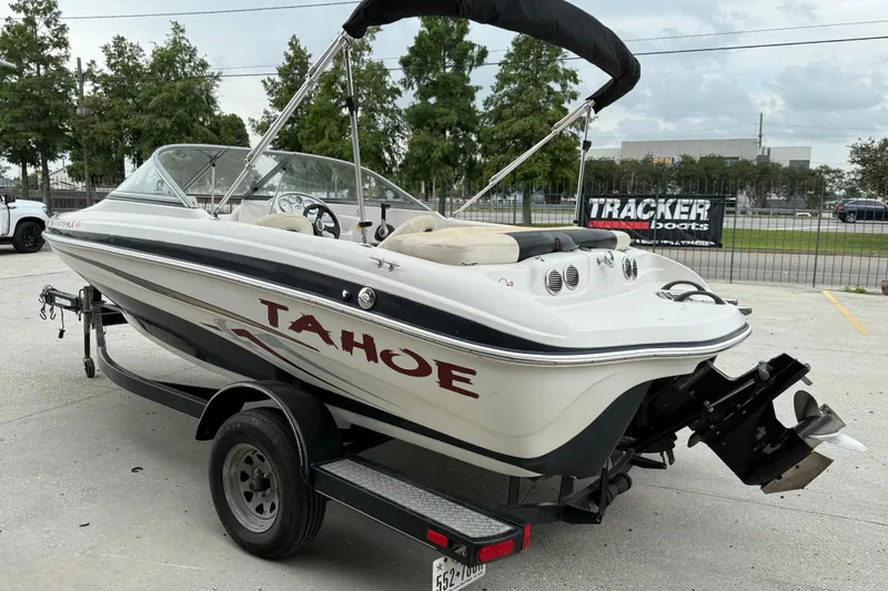 Slide: The Image of 2010 Tahoe Q4 boat on trailer, parked outdoors, with canopy and visible engine. - 5