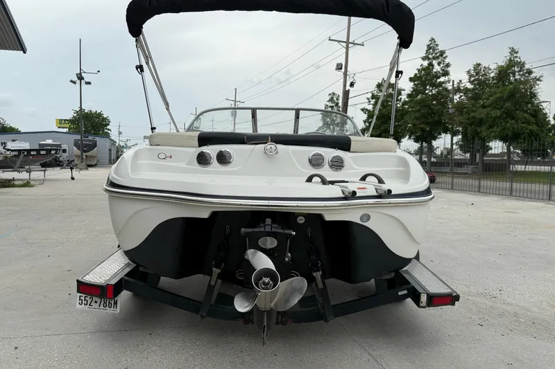 Slide: The Image of 2010 Tahoe Q4 boat on trailer, rear view, parked outdoors. - 6