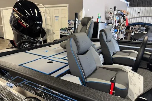 Slide: The Image of 2026 Xpress H20 Bass boat interior with seating and motor in a workshop. - 14