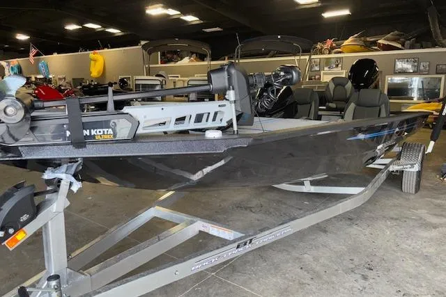 Slide: The Image of 2026 Xpress H20 Bass boat in showroom, featuring Minn Kota trolling motor. - 2