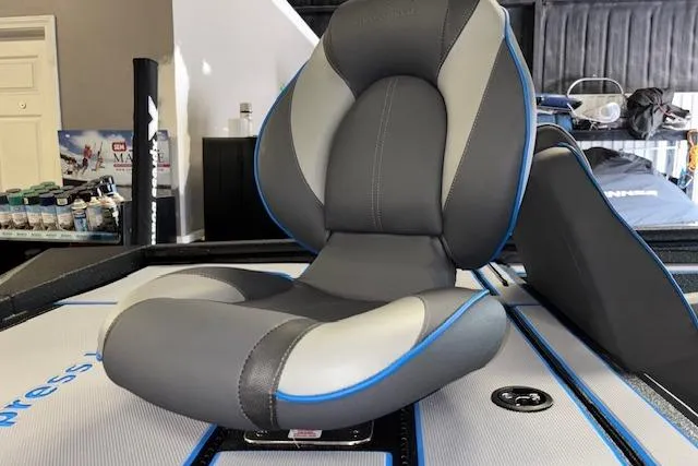 Slide: The Image of 2026 Xpress H20 Bass boat seat with gray and blue accents in showroom. - 23