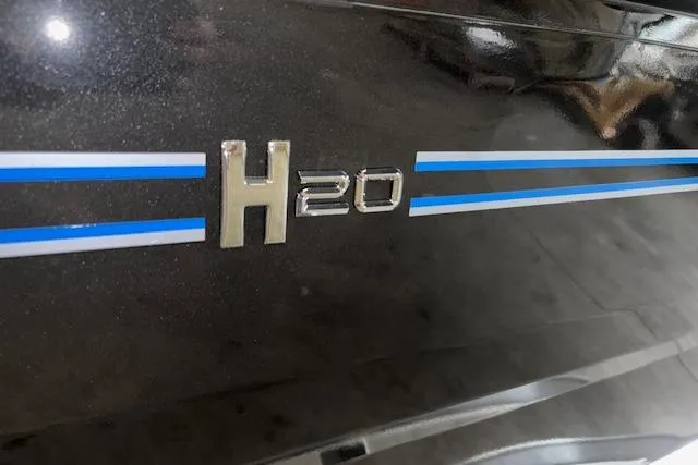 Slide: The Image of 2026 Xpress H20 Bass boat with blue and white stripes on a sleek black surface. - 26