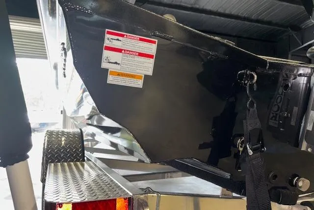 Slide: The Image of 2026 Xpress H20 Bass boat on trailer, showing rear section and warning labels. - 31