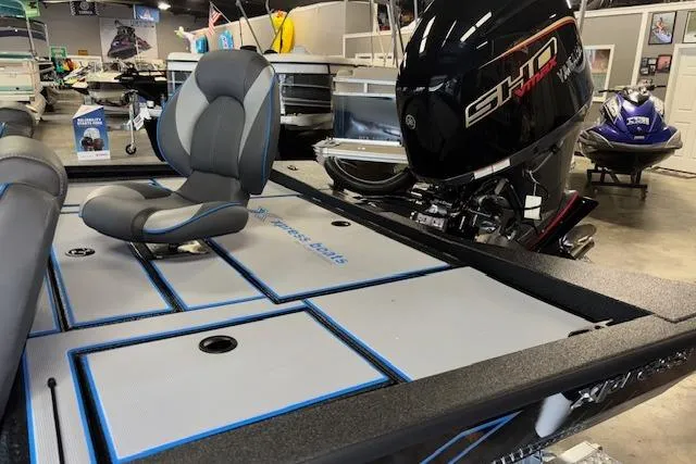 Slide: The Image of 2026 Xpress H20 Bass boat interior with seating and motor in showroom. - 8