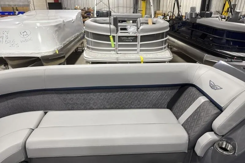 Slide: The Image of 2026 Bennington 24 MFBSF pontoon boat interior with luxurious seating in a showroom. - 17