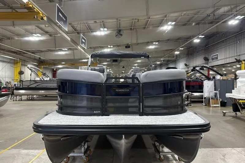 Slide: The Image of 2026 Bennington 24 MFBSF pontoon boat in a spacious indoor showroom. - 4