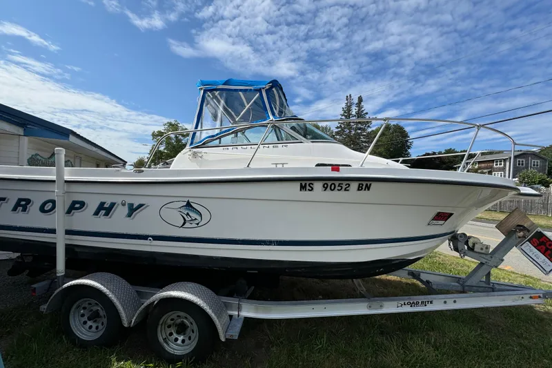 The Image of 1999 Trophy Bayliner boat on trailer, clear sky background, for sale sign visible. - 1