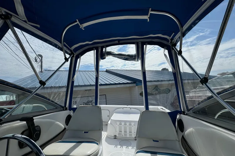 Slide: The Image of 1999 Trophy Bayliner boat interior with blue canopy and seating, under a clear sky. - 9
