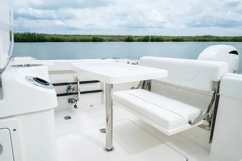 Slide: The Image of Manufacturer Provided Image: 2025 Pursuit S 268 Sport boat interior with white seating and table on calm water. - 17