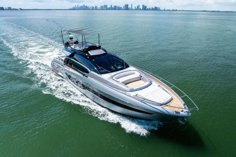 Slide: The Image of Luxurious 2023 Riva 76 PERSEO Super yacht cruising on open water with city skyline backdrop. - 10