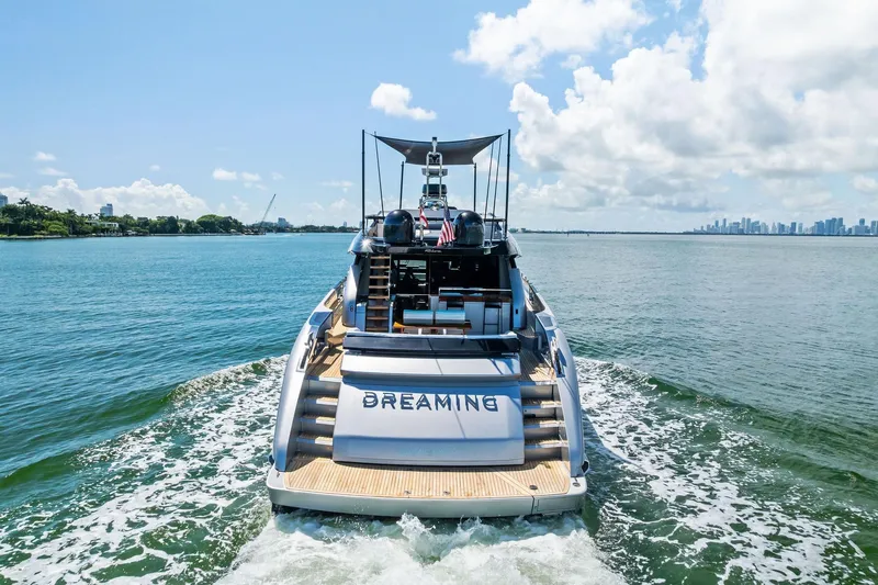 Slide: The Image of 2023 Riva 76 PERSEO Super yacht cruising on open water, city skyline in background. - 2