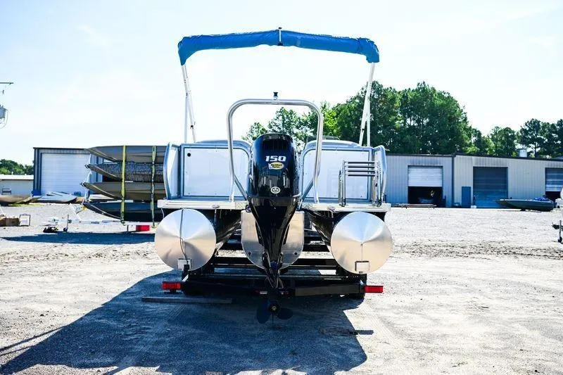 Slide: The Image of 2023 Aloha Pontoon Mahalo 23 with 150 HP engine, parked outdoors. - 2