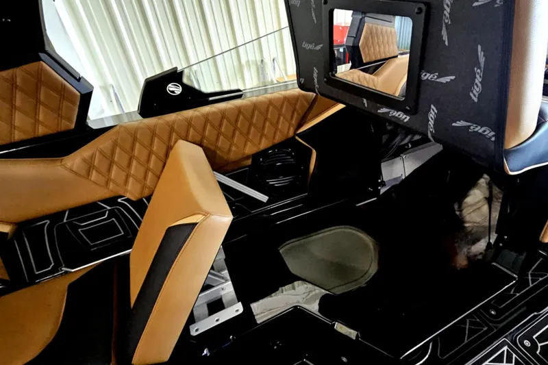 Slide: The Image of 2025 Tigé 22RZX interior with tan diamond-stitched seats and sleek black flooring. - 16