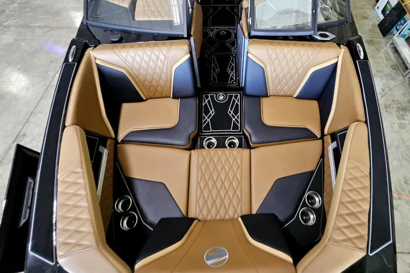 Slide: The Image of 2025 Tigé 22RZX boat interior with luxurious tan and black seating, diamond stitching, and cup holders. - 17