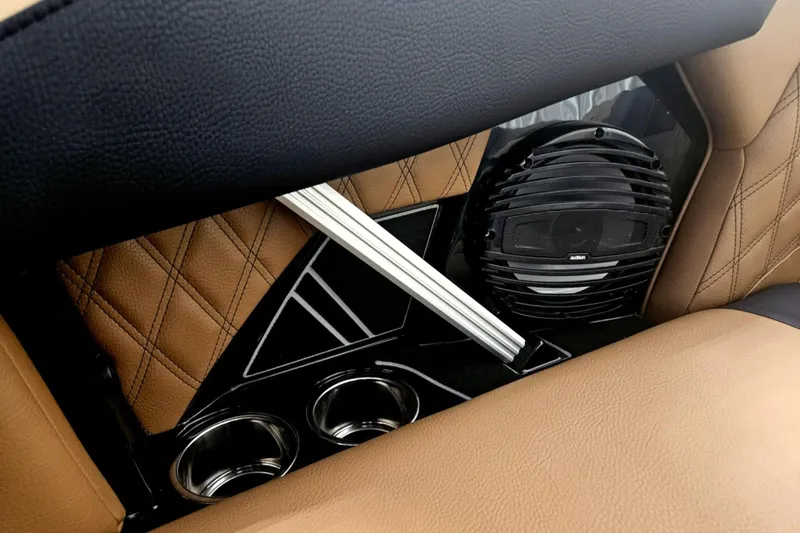 Slide: The Image of 2025 Tigé 22RZX interior detail with speaker, cup holders, and quilted leather upholstery. - 22