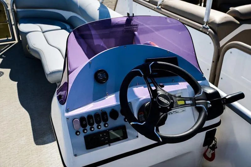 Slide: The Image of 2023 Aloha Pontoon Mahalo 23 steering console with purple windshield and seating area. - 6