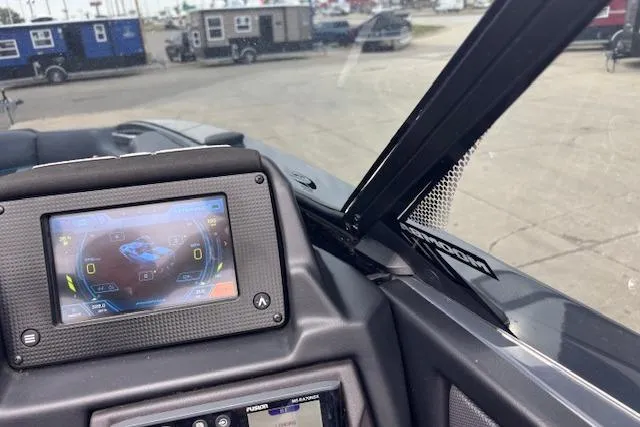 Slide: The Image of 2022 Moomba Kaiyen dashboard with digital display, parked near trailers and vehicles. - 25