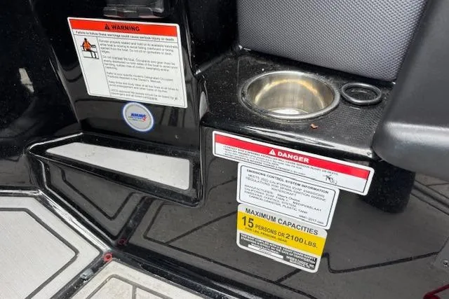 Slide: The Image of 2022 Moomba Kaiyen boat interior with warning labels and cup holder. - 27