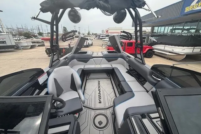 Slide: The Image of 2022 Moomba Kaiyen boat interior with seating and steering wheel, displayed at a dealership. - 32